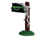 Lemax Spooky Town  Spookytown This Way #44743 at Eerie Emporium - a skeleton hangs on a wood pole connected to a black sign that reads "SPOOKYTOWN THIS WAY!"