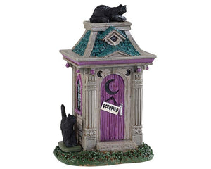 Lemax Spooky Town Haunted Outhouse #94523 at Eerie Emporium - a witchy looking stone outhouse has a purple door with a crescent moon window, green shingled roof and is covered in black cats.