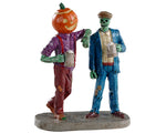 A pumpkin man leans against his well dressed monster buddy as both drink an ale out of a stein. 