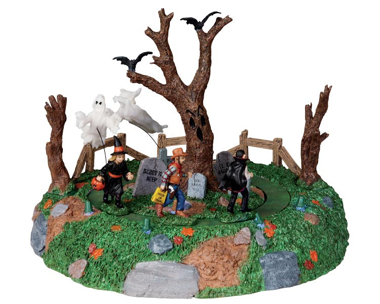 Three trick or treater children, a witch, cowboy and vampire, are being chased around a large spooky tree by two menacing ghosts.