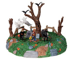 Three trick or treater children, a witch, cowboy and vampire, are being chased around a large spooky tree by two menacing ghosts.
