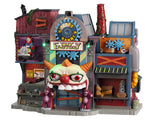 A large factory style building called Hideous Harrys Toy Factory has a main entrance with two purplish teddy bears and an evil clown arch. The rest of the building is covered in random toys and additional clown figures.