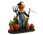 A creepy scarecrow with a pumpkin face and a scythe stands guard over his field while a crow sits on his hat and 4 jack-o'-lanterns rest at his feet. 