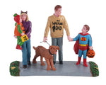 A lovely young family goes for their first trick-or treating-experience. Dad is wearing a shirt that says The Walking Dad. In one hand, he's holding his son's hand, who's dressed up as a superhero. In the other hand, he's walking the dog. Mom is wearing cat ears and she's carrying a young one who is dressed up as a pumpkin.