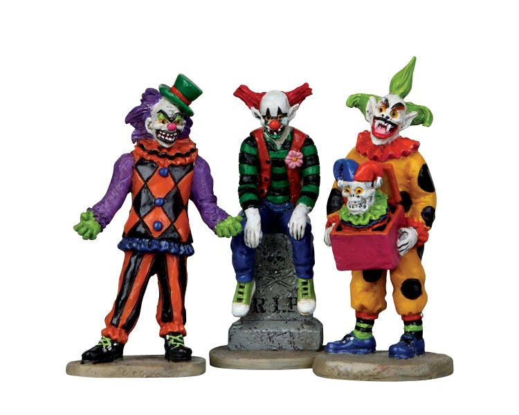 Three extremely evil looking monster clowns dressed in various bright clown outfits plot more mischief.