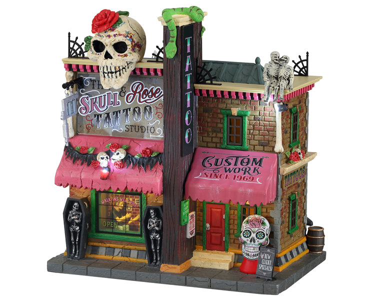 A brick tattoo shop called Skull Rose Tattoo has a large skull on top of it, as well as snakes, skeletons and coffins. 