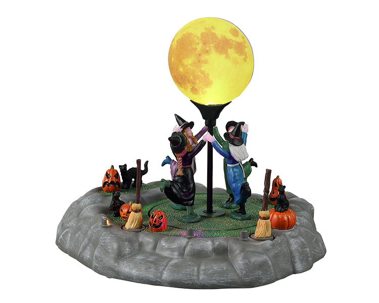 Lemax Spooky Town Dancing In The Moonlight #24931 - 4 witches dressed in various colors hold hands and dance around a full moon. Black cats, broom sticks and jack o' lanterns add to the creepy ambiance.