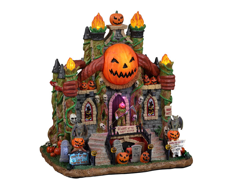 A large stone structure is covered in vines, flames and jack o' lanterns. There are also tombstones and skulls around. On the top of the structure is one massive lite pumpkin and on the main level is a pumpkin creature holding a scythe. 
