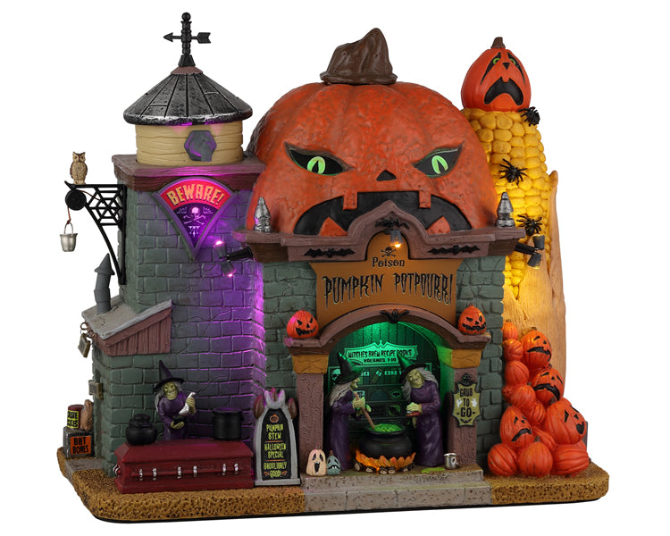 A large  stone building has a massive Jack o' lantern on top with steam that comes out of it. There's a large sign on the building that says "Poison Pumpkin Potpourri" and beneath the sign are witches boiling the days stew in a cauldron. There is a large stack of pumpkins next to the building in addition to a huge spider covered cob of corn.