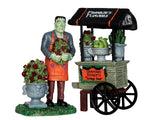 A friendly green monster holds a bouquet of flowers standing next to his flower stand.