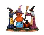 Lemax Spooky Town Pumpkin Witch #32193 - Two witches, one dressed in purple and the other in violet, decorate a snowman to look like a fellow witch.