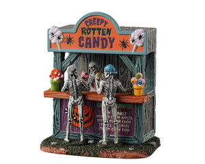 
            
                Load image into Gallery viewer, Lemax Spooky Town Rotten Candy Stand #33612 - A mini wooden structure has one skeleton serving two skeletons monster candy.
            
        