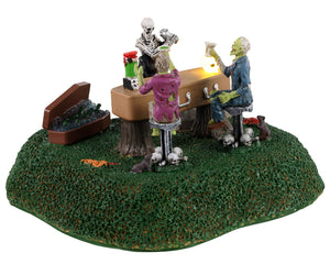 
            
                Load image into Gallery viewer, Lemax Spooky Town Coffin Bar #34062 - A skeleton bartender serves cocktails to two zombies while rats and skulls rest at their feet.
            
        