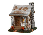 Lemax Spooky Town Skeleton Cottage #34081 - a mini brown house with a tin roof is covered in skulls and bones.