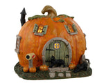 Lemax Spooky Town Pumpkin Cottage #34082 - a mini house made of a jack o' lantern with a green doorhas black cats and out front.