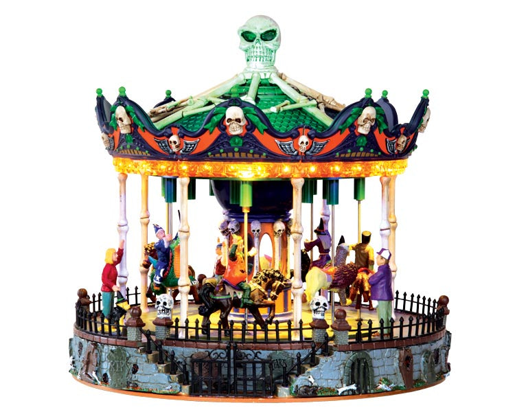 A creepy merry-go-round with a skeleton head and bones on top is full of cute costumed children riding various animals and their parents who watch. The entire piece is illuminated with an eerie glow that bounces off the many additional skeleton head accents.