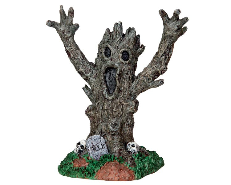A creepy tree monster opens its mouth wide and raises its branch arms above it's head to scare off intruders. A tombstone and skulls sit at its base.