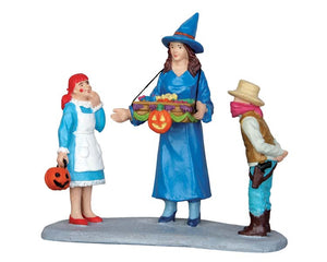 
            
                Load image into Gallery viewer, A festive mom dressed as a witch offers a tray of delicious treats to two costumed children, one dressed as Raggedy Ann and the other as a cowboy. 
            
        