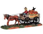 A sinister Scarecrow sits on a wooden wagon full of Jack-o'-lanterns, pulled by a horse. The wagon reads "Spooky Farm Pumpkins"