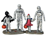 A family of mummies including Mom, Dad and two children go trick or treating together. The boy mummy is also wearing a Batman costume while the girl mummy is dressed as a princess.