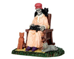 A scary sitting skeleton lady is covered in cats.
