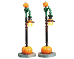 Spooky Gothic lamp posts have large pumpkins at their base, small jack-o'-lanterns up top, and a curled light in the center that's topped by a witch hat. 