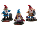3 zombie garden gnomes stand next to each out sandwiched between mushrooms and tombstones. Two of the Gnomes are male and both are missing and arm while the only female still has all her limbs.