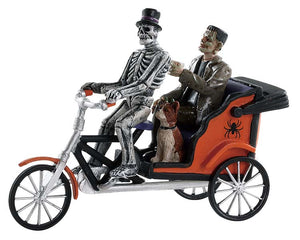 
            
                Load image into Gallery viewer, A skeleton drives a pedicab while Frankenstein and his dog ride in the back of the orange cart.
            
        