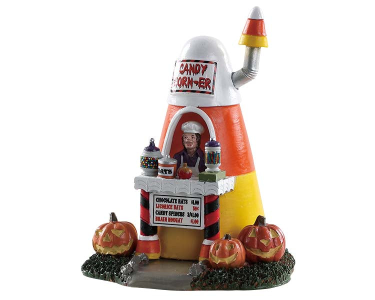 
            
                Load image into Gallery viewer, A man that looks like a vampire sells various candy out of a small structure that has the shape and color of a piece of candy corn. Three jack-o&amp;#39;-lanterns sit in front of the sturucture.
            
        