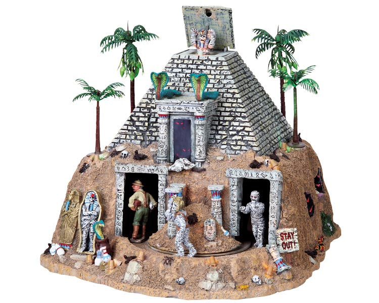 Mummies chase an explorer in and out of a large pyramid, while the peak of the pyramid opens and reveals another mummy. Palm trees, cobras and additional Egyptian artifacts are scattered throughout the entire scene.