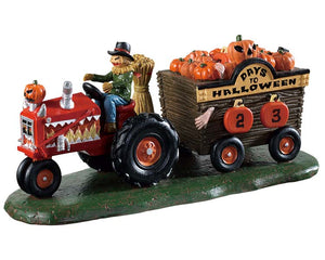 
            
                Load image into Gallery viewer, a sinister scarecrow rides a tractor while pulling a wagon full of pumpkins. on the wagon is a sign that reads Days to Halloween.
            
        