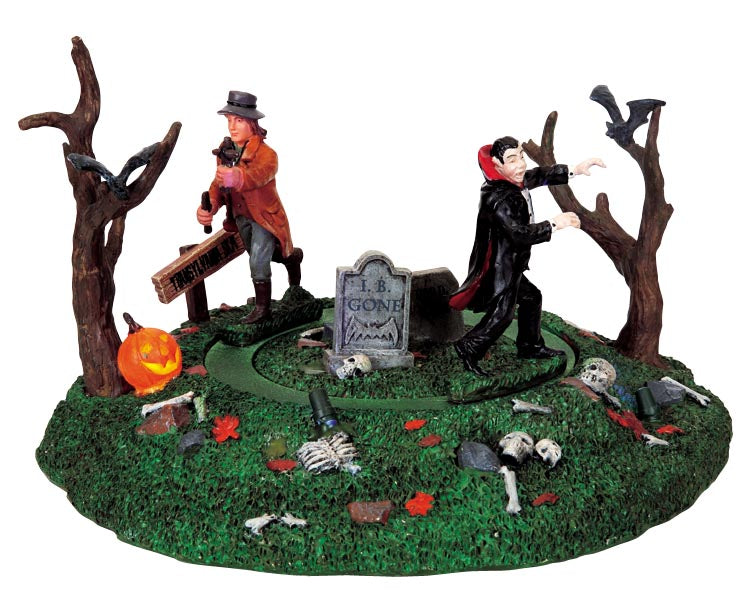 
            
                Load image into Gallery viewer, A vampire slayer with a wooden stake chases a vampire through a graveyard with two creepy trees and a jack-o&amp;#39;-lantern.
            
        