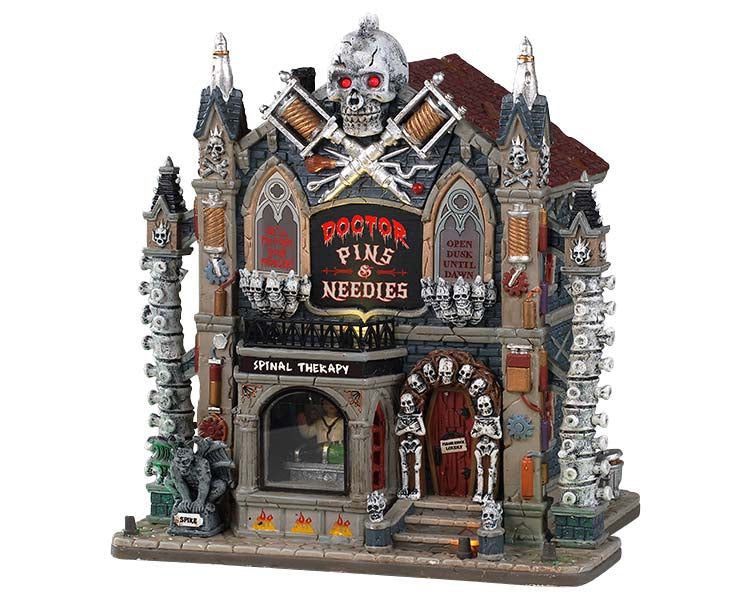A large Skull with Red eyes sits atop a skeleton, skull and bone covered gothic building, while a menacing Gargoyle keeps lookout up front. A creepy doctor operates on a poor victim inside a large front window. 