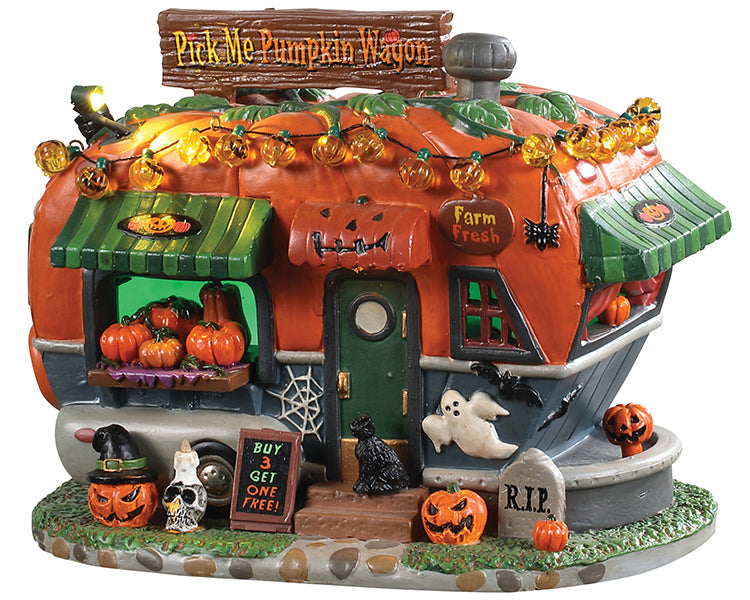 A pumpkin themed trailer is overflowing with jack-o'-lanterns and various gourds. Pumpkin string lights line the top of this scene, while a ghost, black cat, spider, skeleton and tombstone add a spooky touch.
