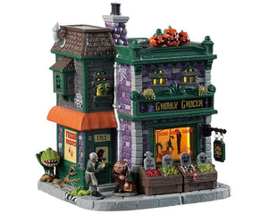 A green and purple color accented grocery store is full of monsters bursting out of the windows and hanging out in front of the store. Rotted fruit and mini tombstones appear out front while 3 sinister pumpkins sit atop the store. 