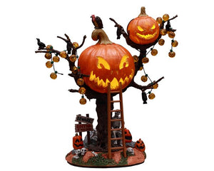 A ladder leads up to a large Jack-o'-lantern faced treehouse that's topped by a vulture and surrounded by pumpkin string lights. A slightly smaller and more sinister jack-o'-lantern treehouse sits up to the right of the main section. Below are multiple jack-o'-lanterns, skulls and a sign that reads BEWARE! ENTER IF YOU DARE!