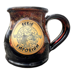 Eerie Emporium's Witch Monster Coffee Mug - A witch smiles in a forest while black cats stare besides her.