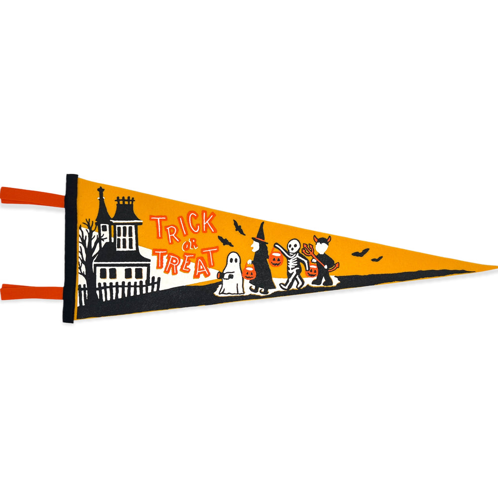 A gold pennant has four trick or treaters, a ghost, witch, skeleton and devil walking towards a spooky house. The words "trick or treat" are written in vintage Halloween font on the pennant.