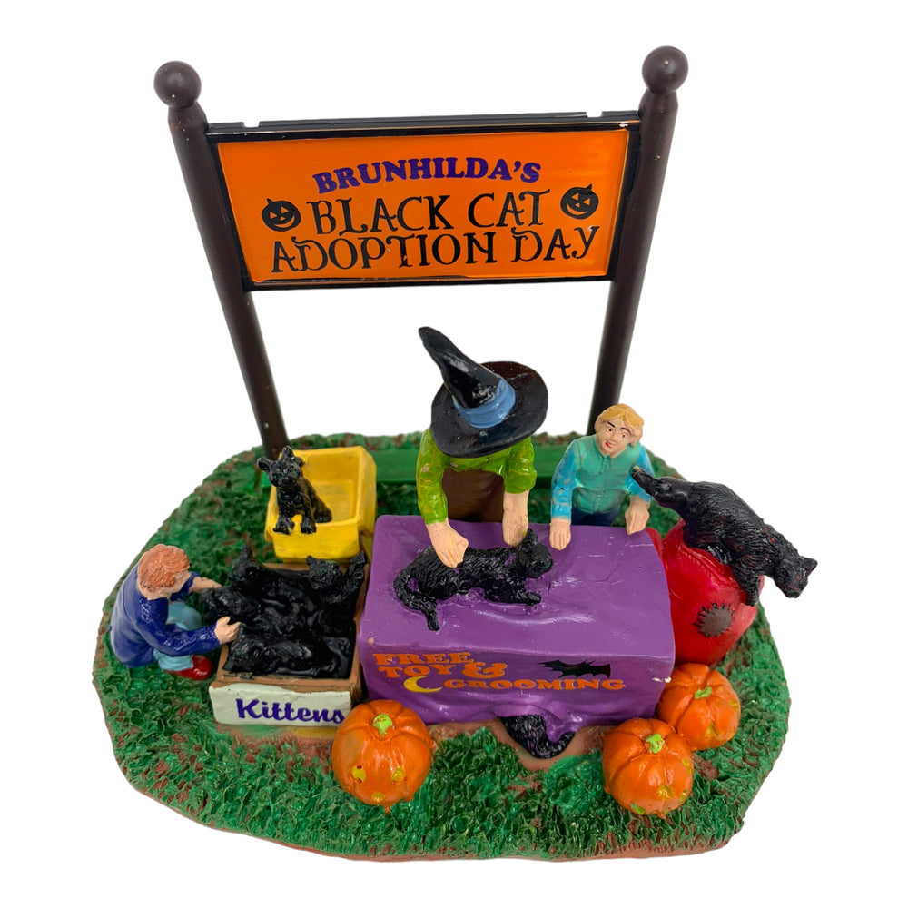 
            
                Load image into Gallery viewer, Retired Lemax Spooky Town Black Cat Adoption #43067 - A mom dressed as a witch celebrates Halloween with her children surrounded by black cats and jack o&amp;#39; lanterns.
            
        