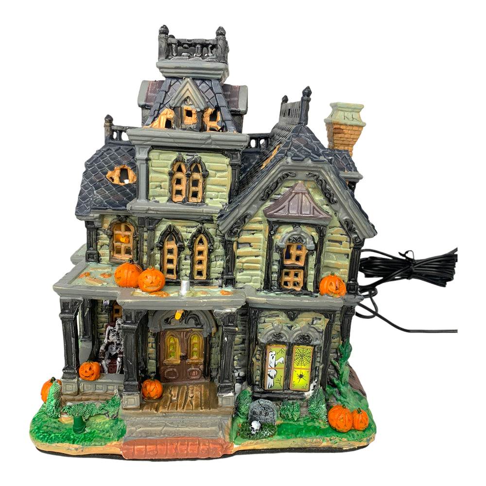 Retired Lemax Spooky Town Dreadful Manor #85708  - A dilapidated creepy mansions is covered in jack o lanterns, tombstones and skeletons.