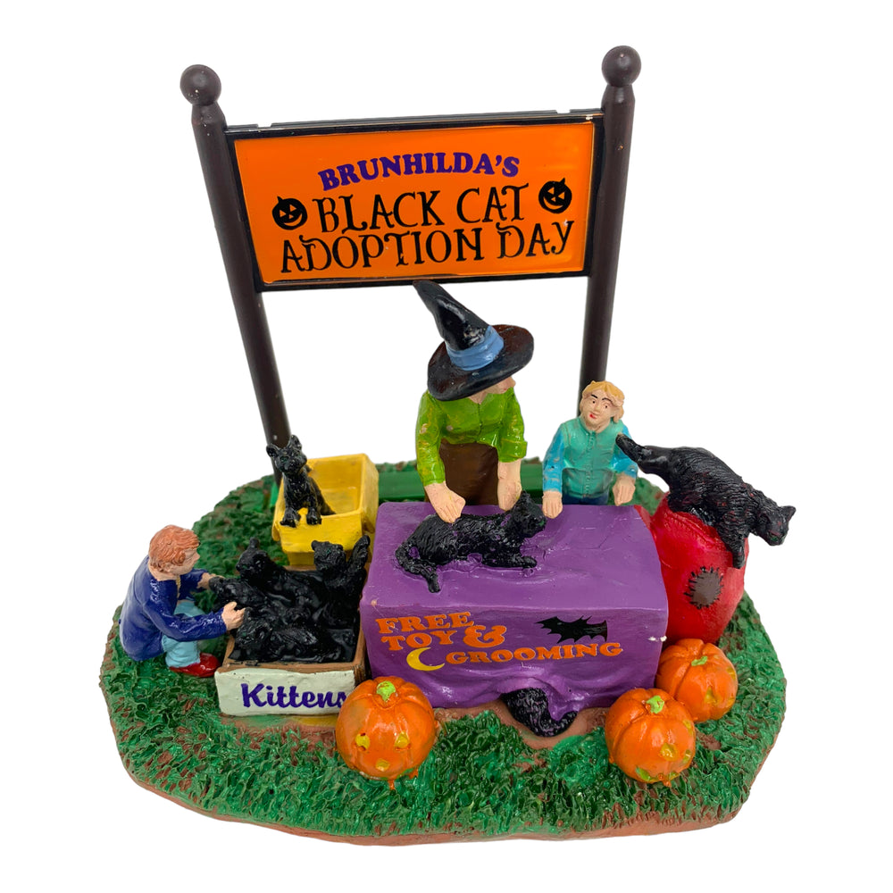 
            
                Load image into Gallery viewer, Retired Lemax Spooky Town Black Cat Adoption #43067 - A mom dressed as a witch celebrates Halloween with her children surrounded by black cats and jack o&amp;#39; lanterns.
            
        