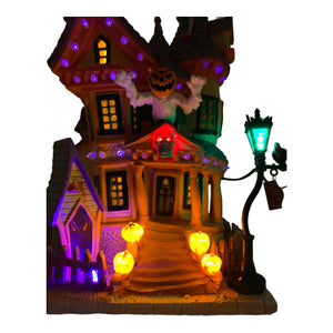 
            
                Load image into Gallery viewer, Retired Lemax Spooky Town Nightmare On Oak St. #75492 - A kooky bright red, yellow, green and purple house has crooked peaks, a giant pumpkin headed creature and jack o lanterns coming out of it.
            
        