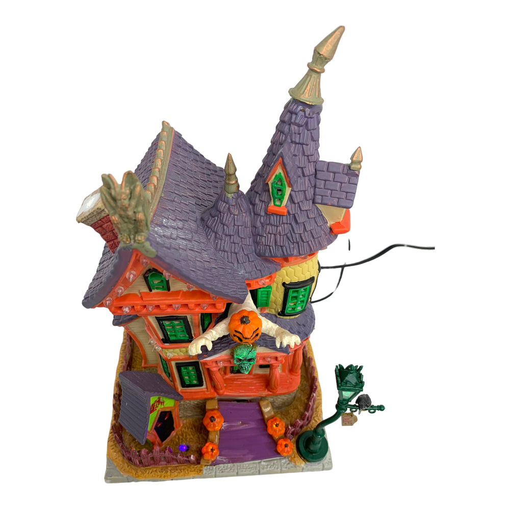 
            
                Load image into Gallery viewer, Retired Lemax Spooky Town Nightmare On Oak St. #75492 - A kooky bright red, yellow, green and purple house has crooked peaks, a giant pumpkin headed creature and jack o lanterns coming out of it.
            
        