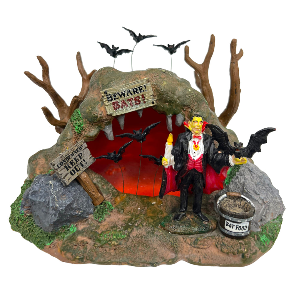 Retired Lemax Spooky Town Bat Lair #93724. Dracula stands with a candle in front of a cave.